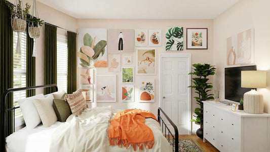 White bed with orange blanket with art on the wall