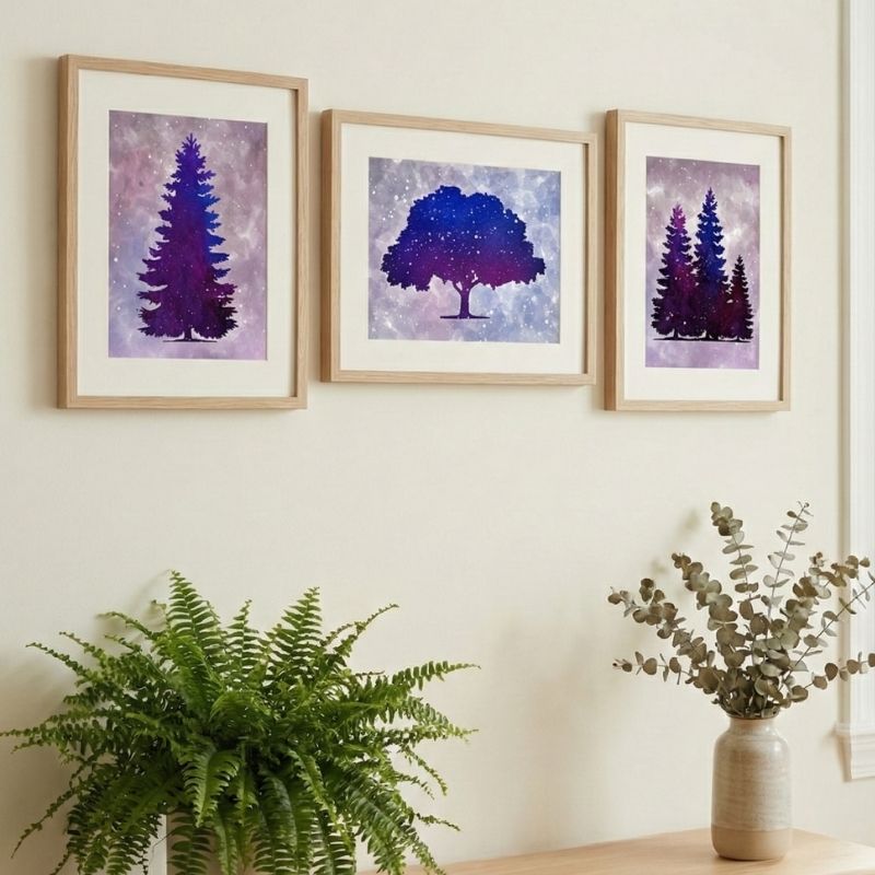 Three framed artworks by Jessica Adamec on a wall with a plant and vase in the foreground.